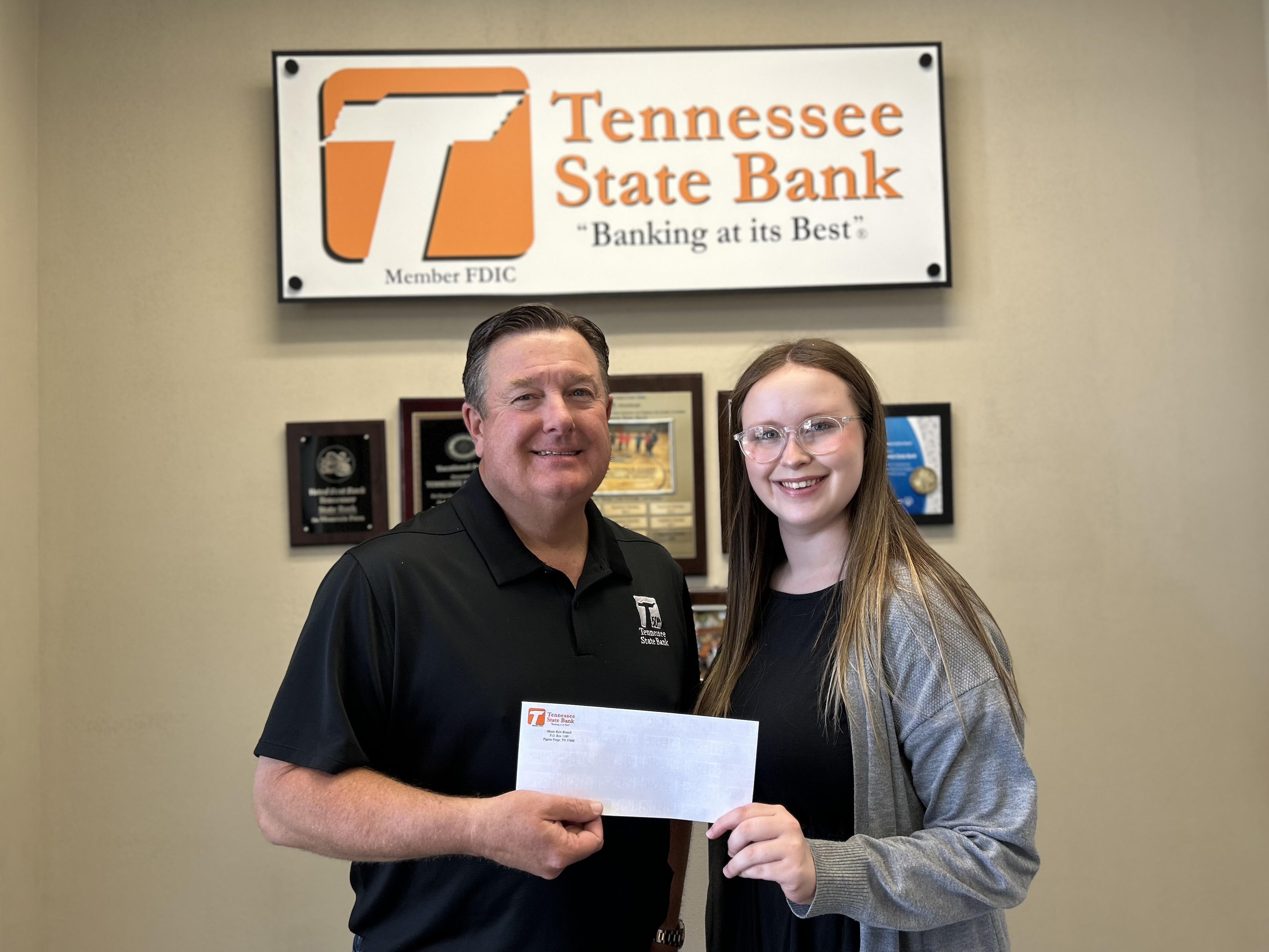 Todd Proffitt handing a check to Drew Johnson, 4H Scholarship Recipient